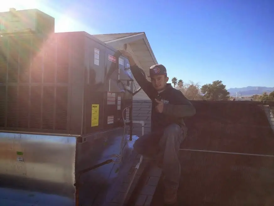 HVAC technician performing AC Tune-Up on a rooftop unit in South Holland